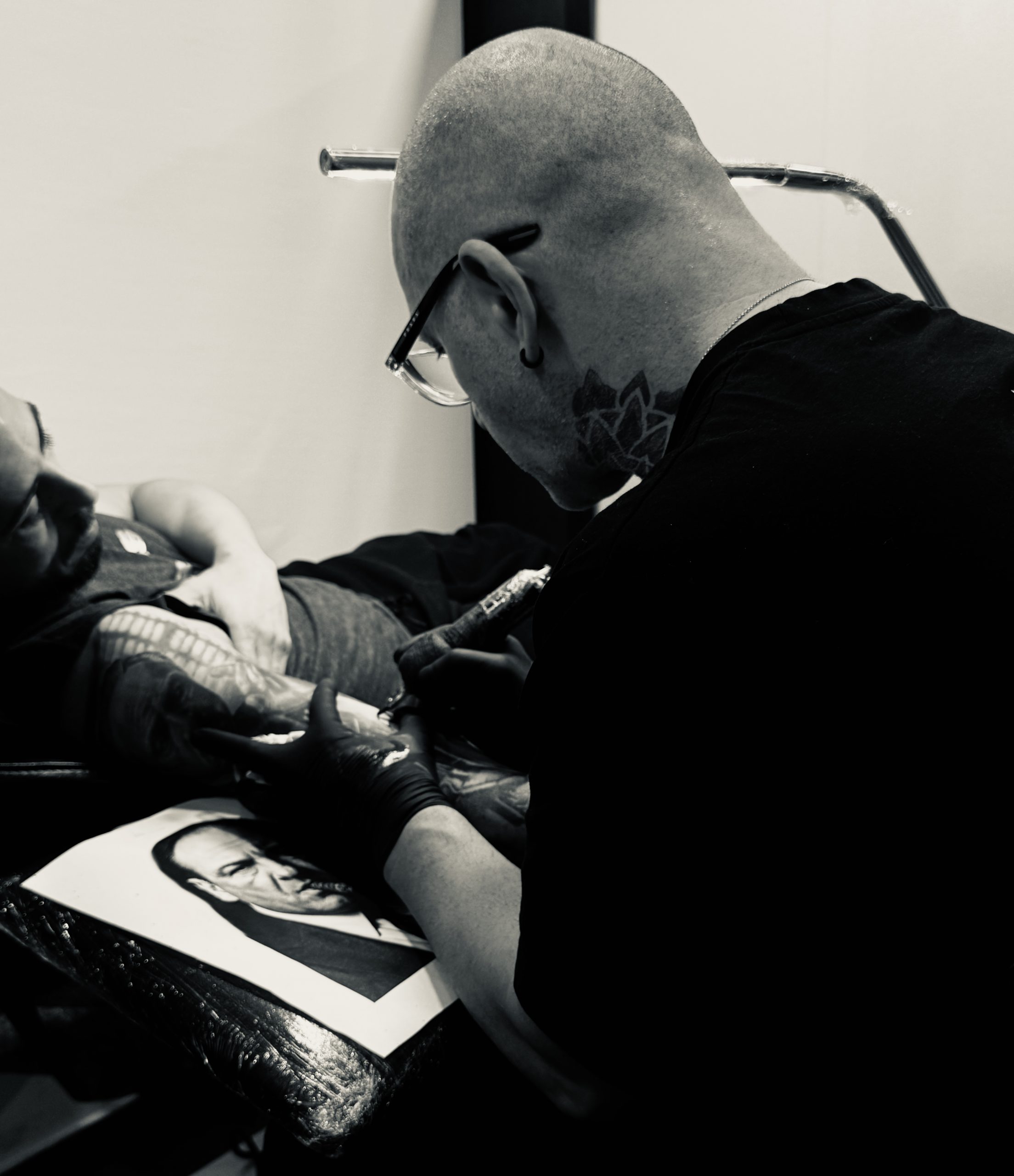 Tatuador especialista en retratos hiperrealistas en Madrid trabajando en diseño Black & Grey con máxima precisión en luces y sombras.